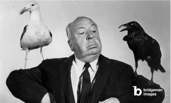 Alfred Hitchcock mit einer Möwe und einem Raben auf seinen Schultern