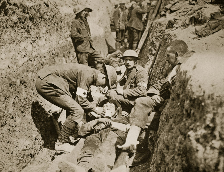 Red Cross men in the trenches attending to a wounded man, 1916 (sepia photo) by English Photographer/ The Stapleton Collection 